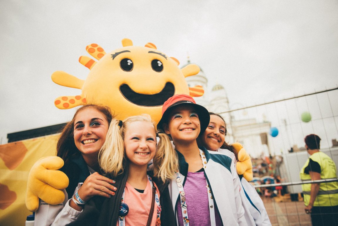 Gymnaestrada maskotti ja neljä nuorta tyttöä