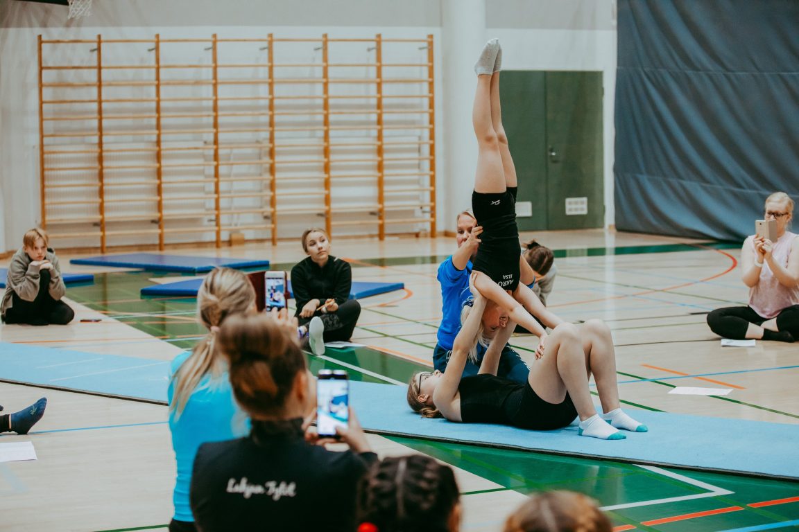 Kouluttaja avustaa akrobatialiikettä