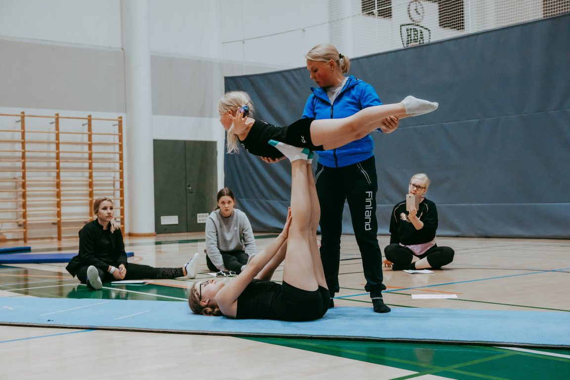 Nainen avustaa akrobatiaa